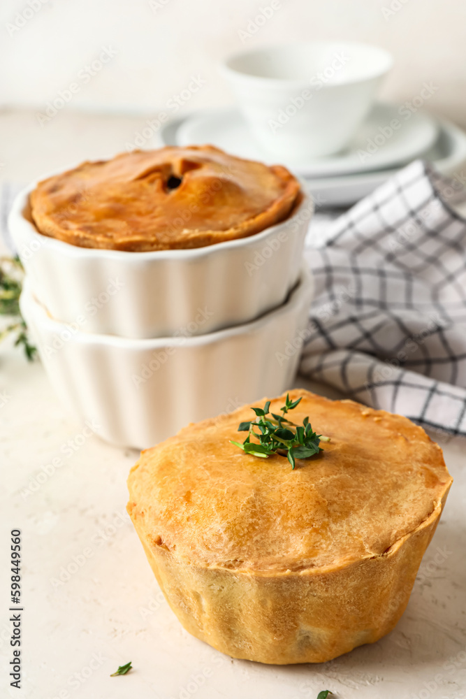 Tasty meat pot pies on light background