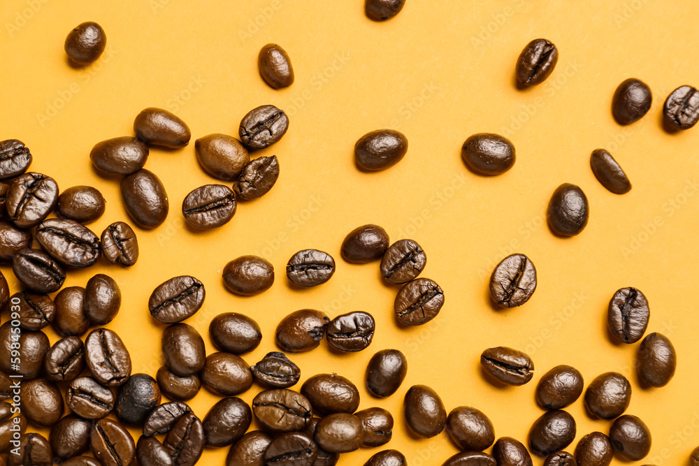 Scattered coffee beans on orange background