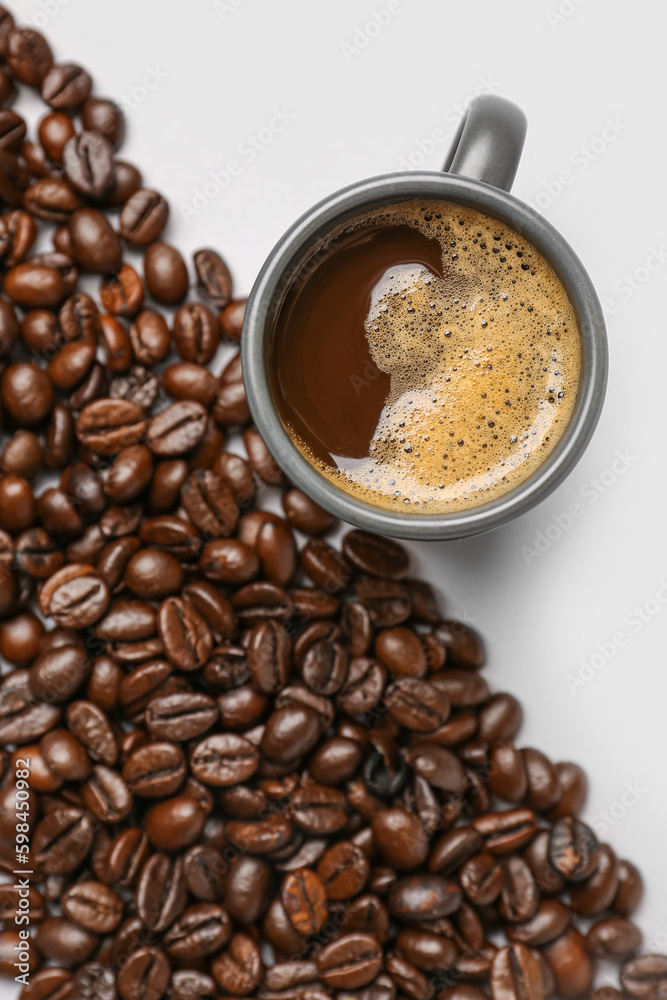 Cup of coffee and beans on grey background