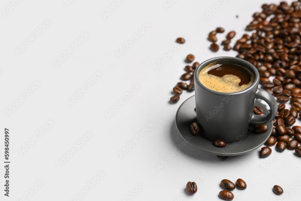 Cup of coffee and beans on grey background