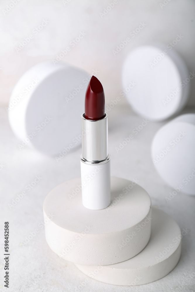 Decorative plaster podiums and lipstick on light background