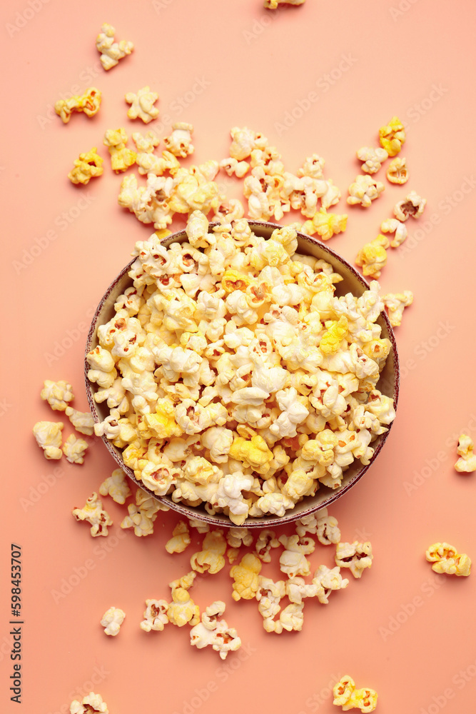 Bowl with crispy popcorn on beige background