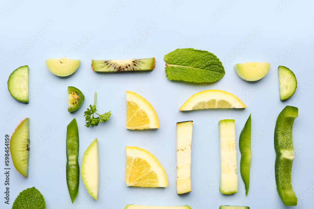 Composition with green fresh fruits and vegetables on blue background