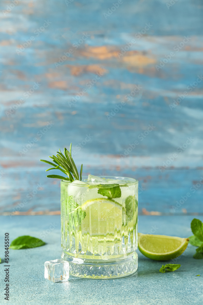 Glass of tasty mojito on blue background