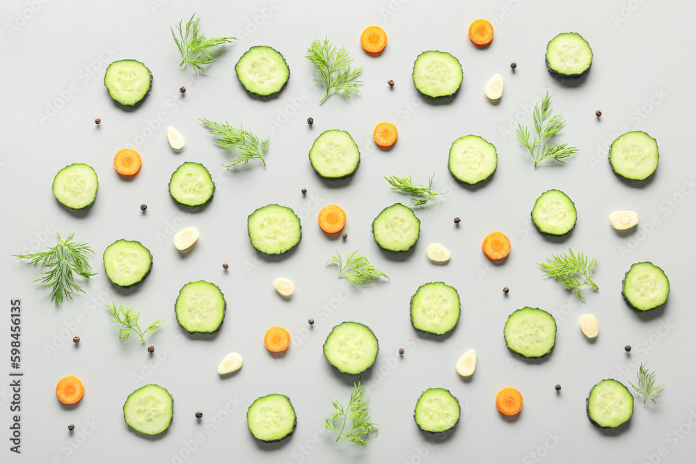 Slices of cucumber with dill and carrot on grey background