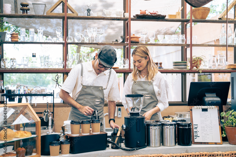 Asian attractive barista and Caucasian waitress working in coffeehouse. 