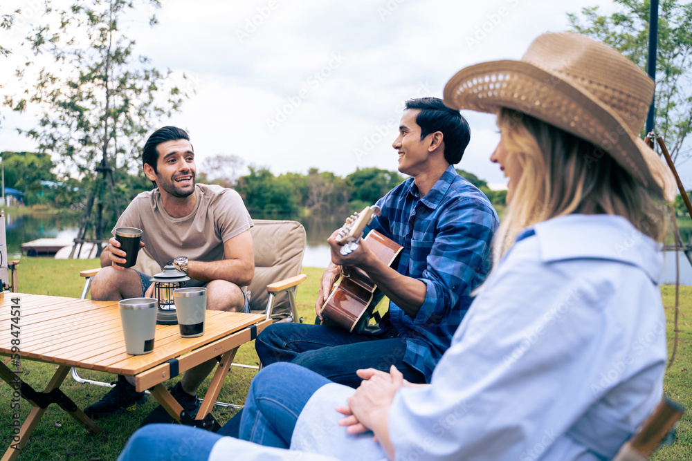 Group of diverse friend having outdoors camping party together in tent. 