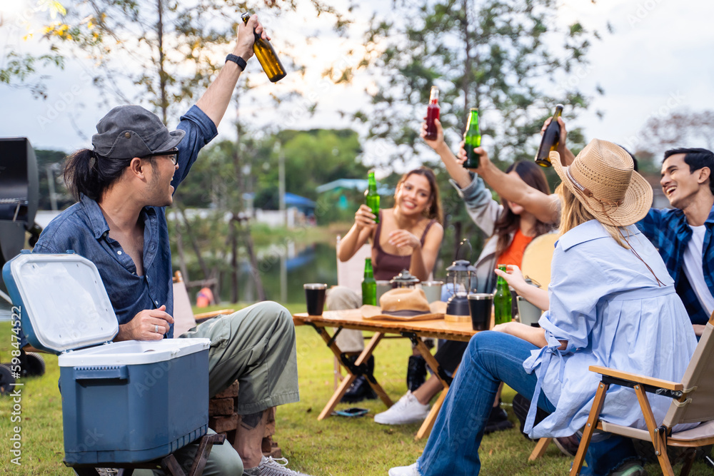 Group of diverse friend having outdoors camping party together in tent. 