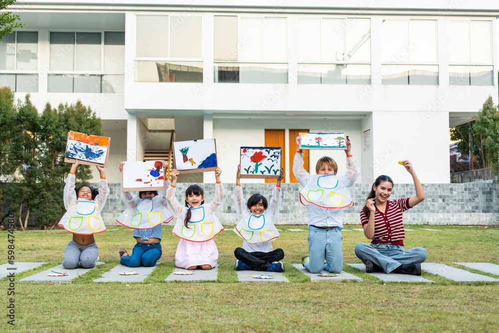 Portrait group of young student paint board outdoors in school garden. 