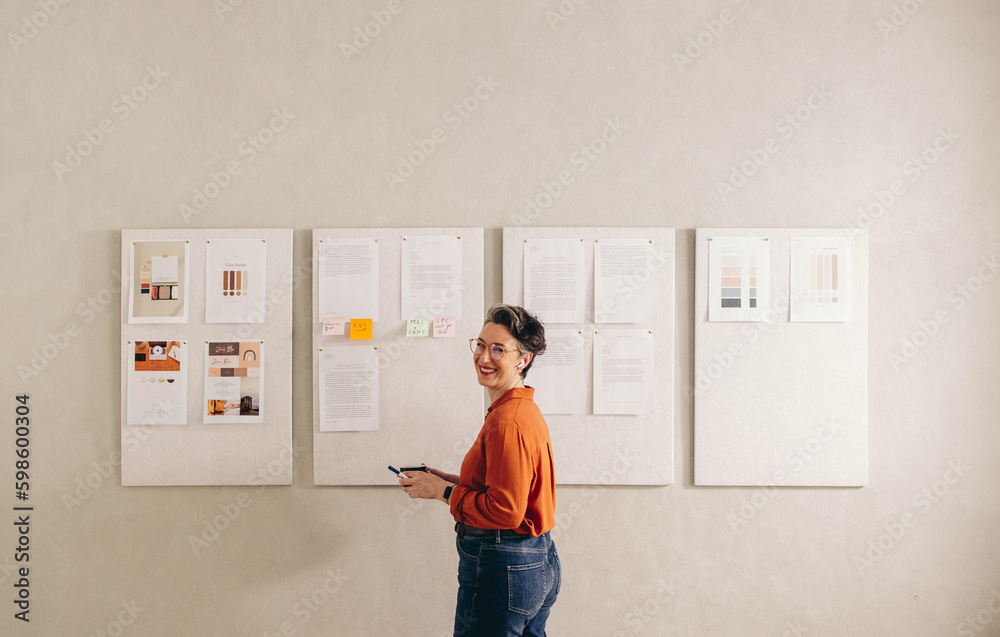 Happy businesswoman smiling at the camera in a creative office