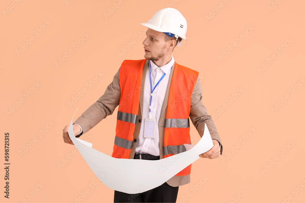 Male architect with drawing on beige background