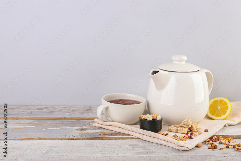 Teapot, cup of tea and dried fruits mix on white wooden table