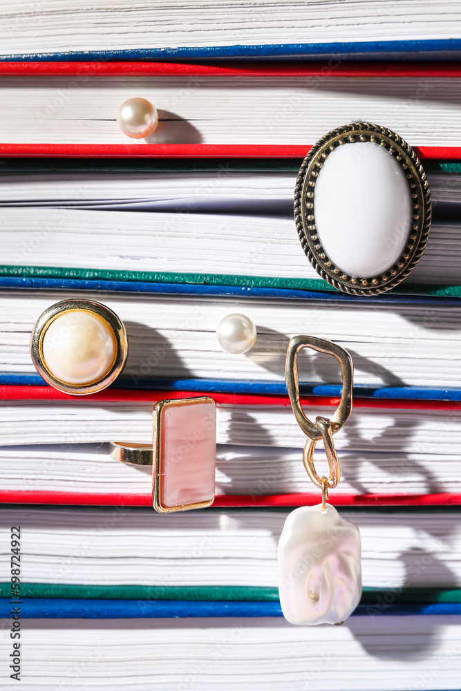 Books with stylish jewelry, closeup