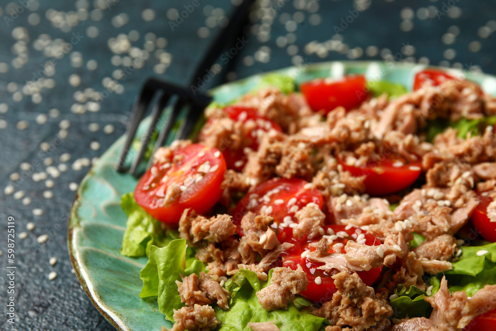 Plate with delicious tuna salad on dark table