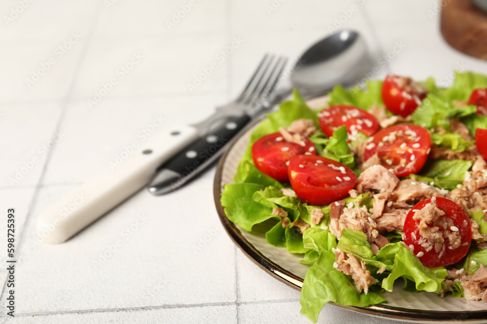 Plate with delicious tuna salad on white tiled table