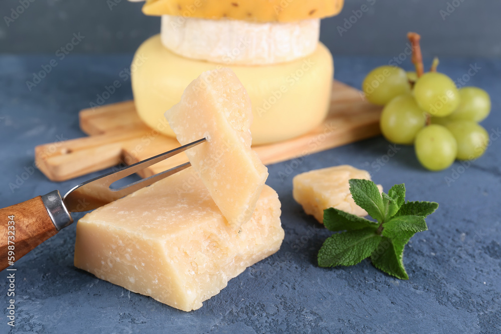 Fork with pieces of tasty cheese on table, closeup