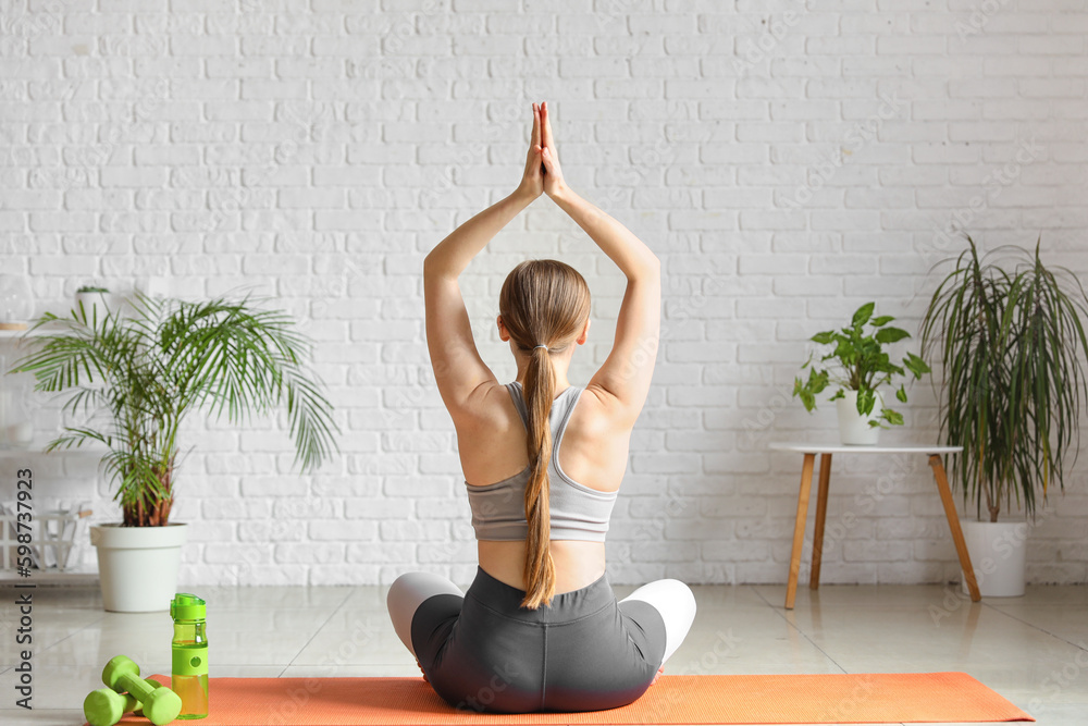 Sporty young woman doing yoga at  home