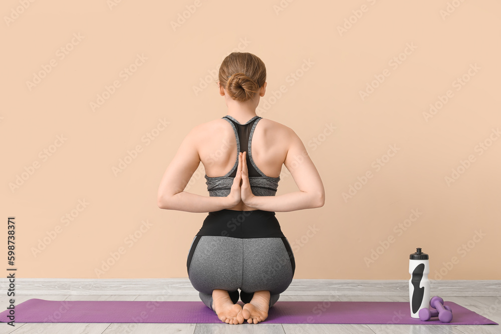 Sporty young woman doing yoga indoors