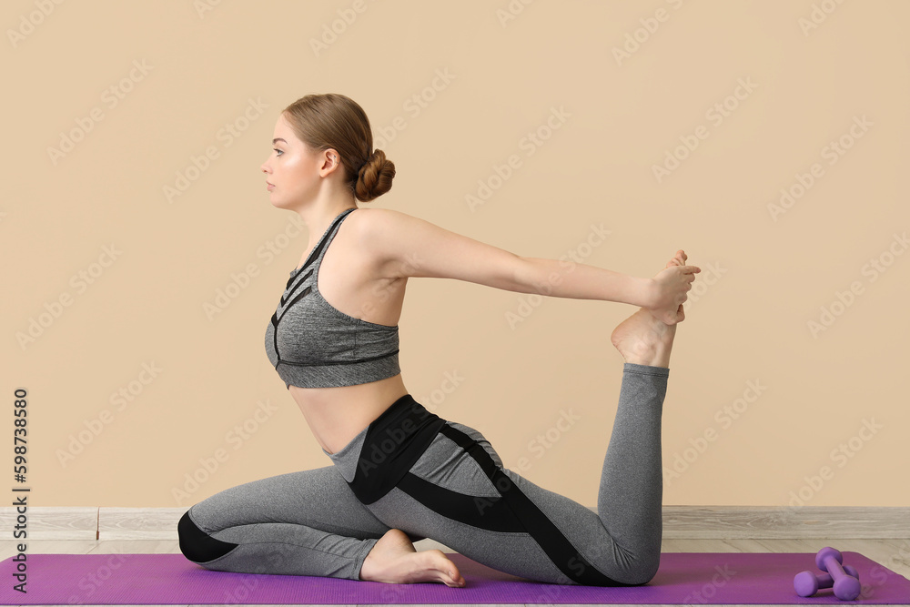 Sporty young woman doing yoga indoors