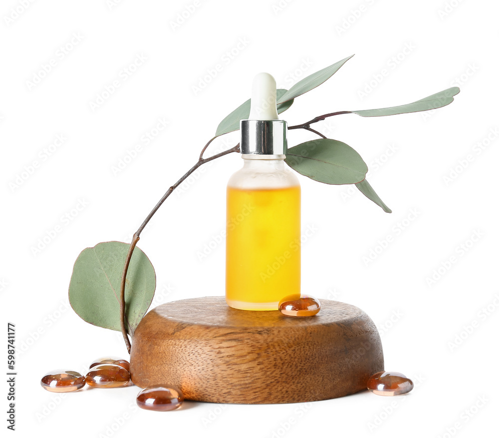 Bottle with cosmetic oil on wooden stand, eucalyptus branch and stones on white background