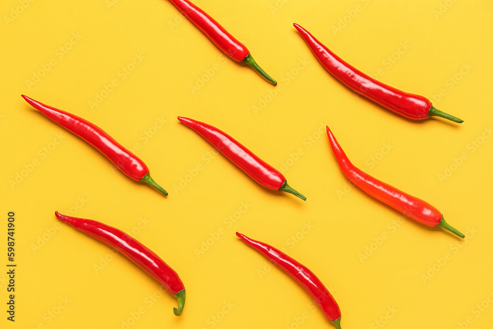 Fresh hot chili peppers on yellow background