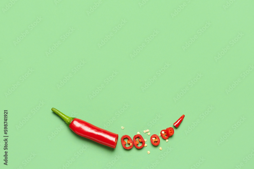 Cut hot chili pepper on green background