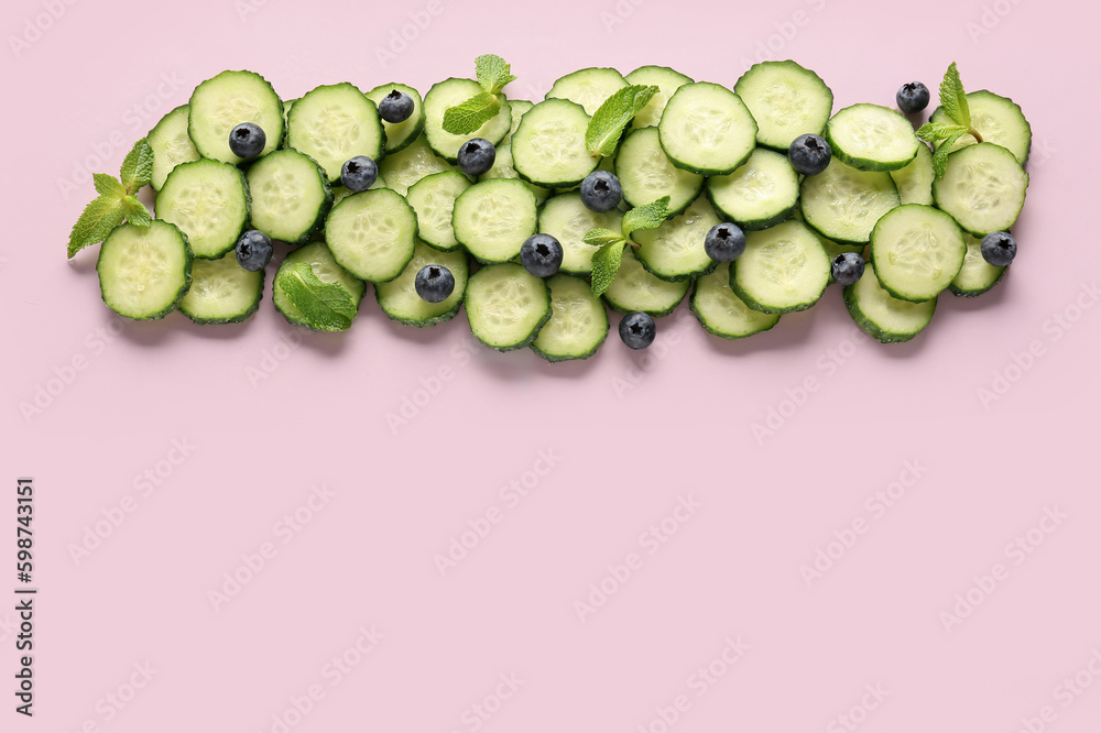 Slices of cucumber with blueberry and mint on lilac background