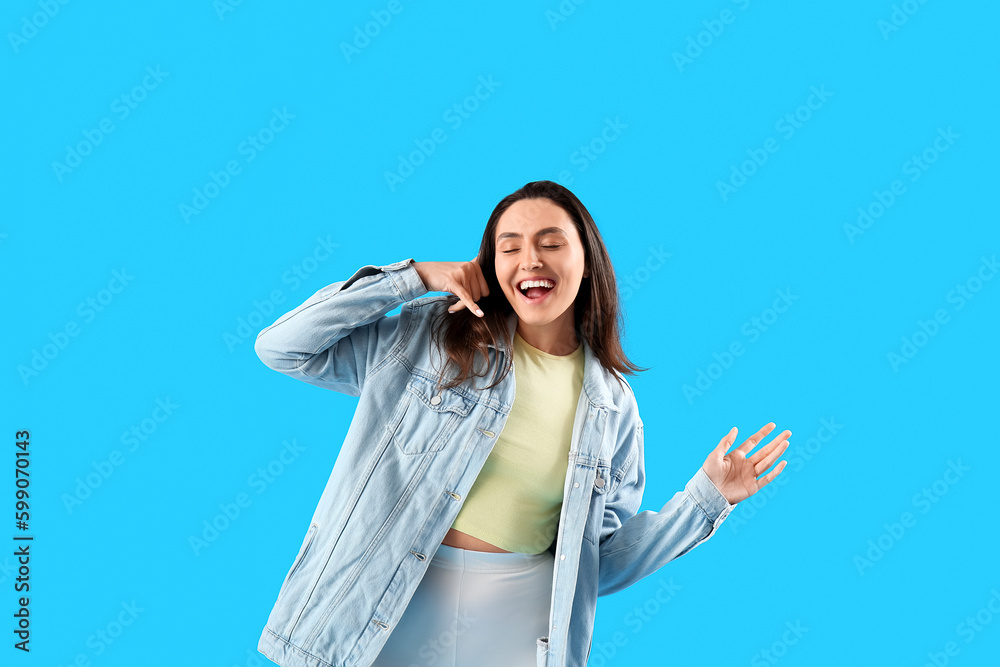 Cool young woman showing  call me  gesture on light blue background