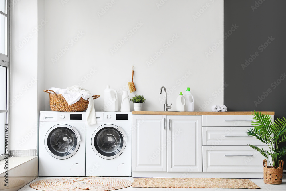 Interior of laundry room with washing machines and dirty clothes