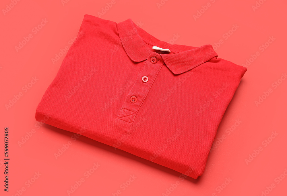 Folded red t-shirt on color background