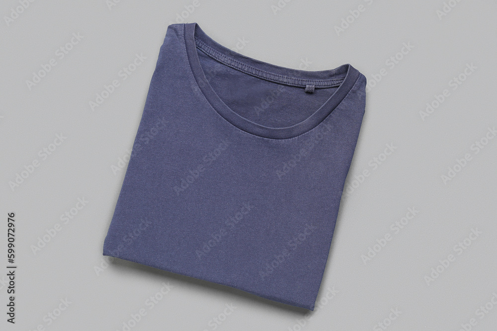 Folded blue t-shirt on grey background