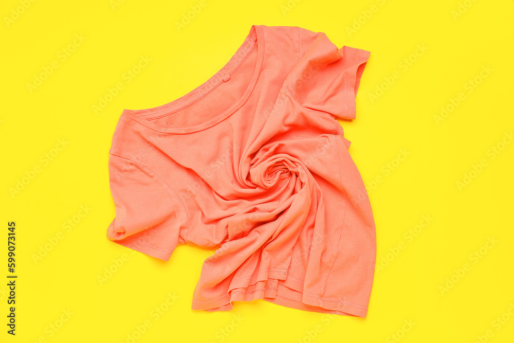 Crumpled pink t-shirt on yellow background