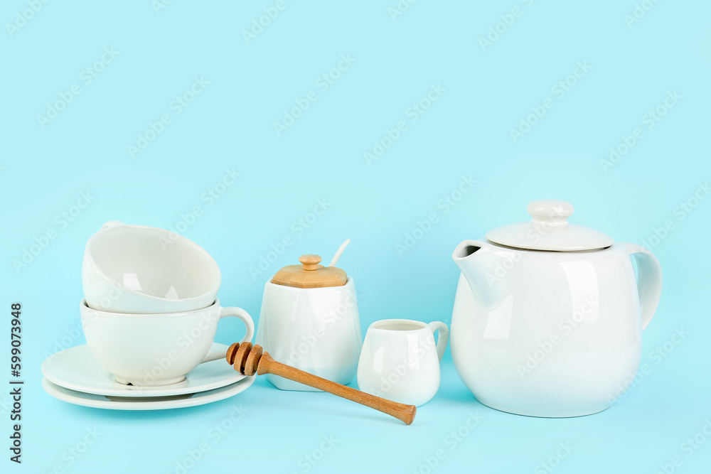 Stylish tea set on blue background