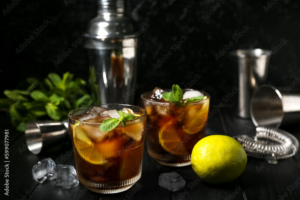 Glasses of cold Cuba Libre cocktail on dark background