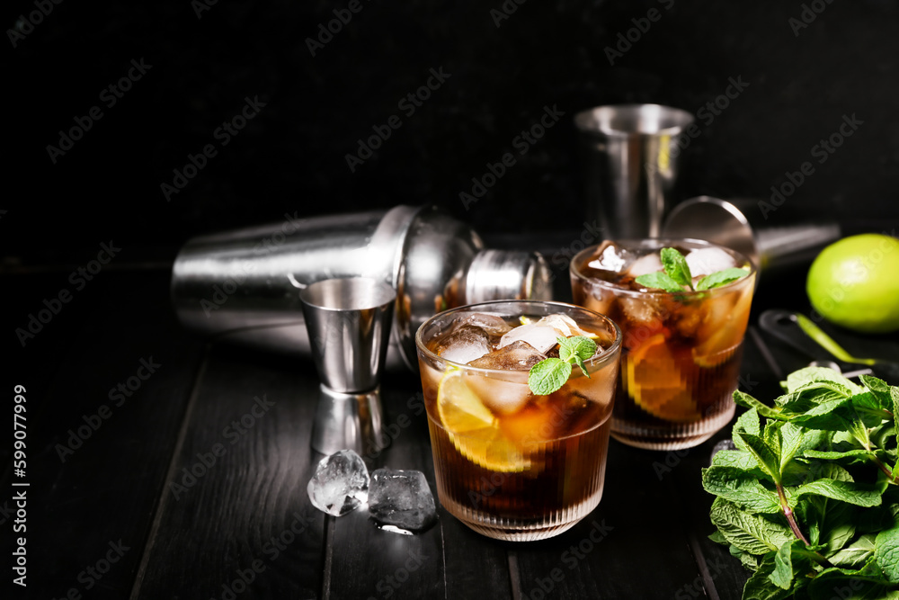 Glasses of cold Cuba Libre cocktail on dark background