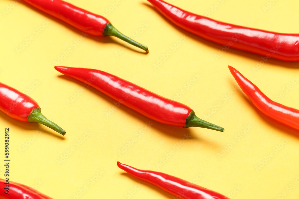 Fresh hot chili peppers on yellow background