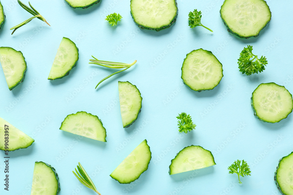 Slices of cucumber with rosemary and parsley on turquoise background