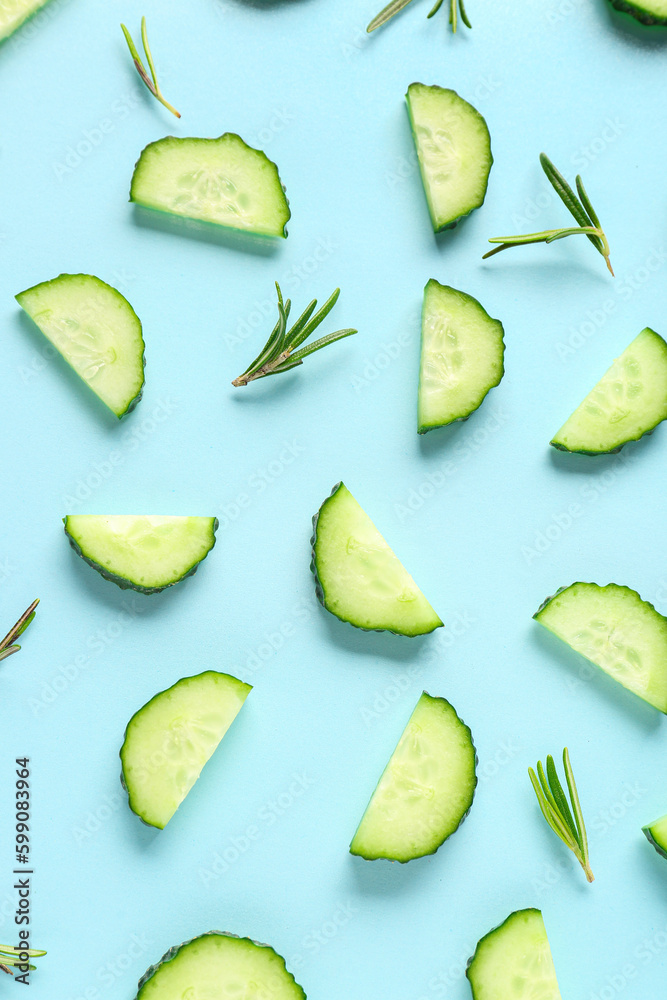 Slices of cucumber with rosemary on turquoise background