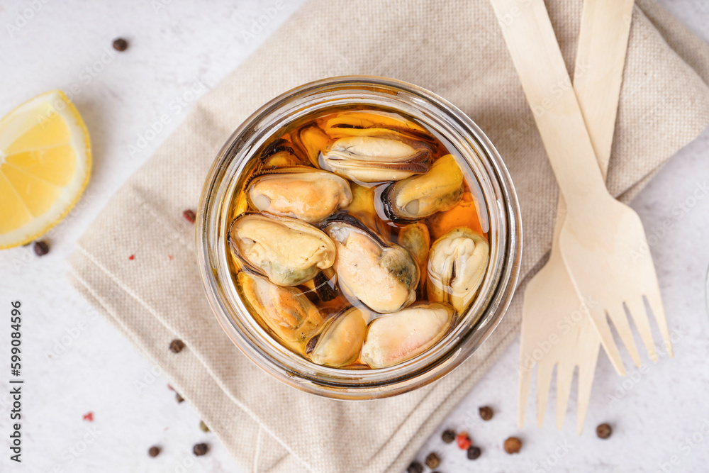 Jar with pickled mussels on white background