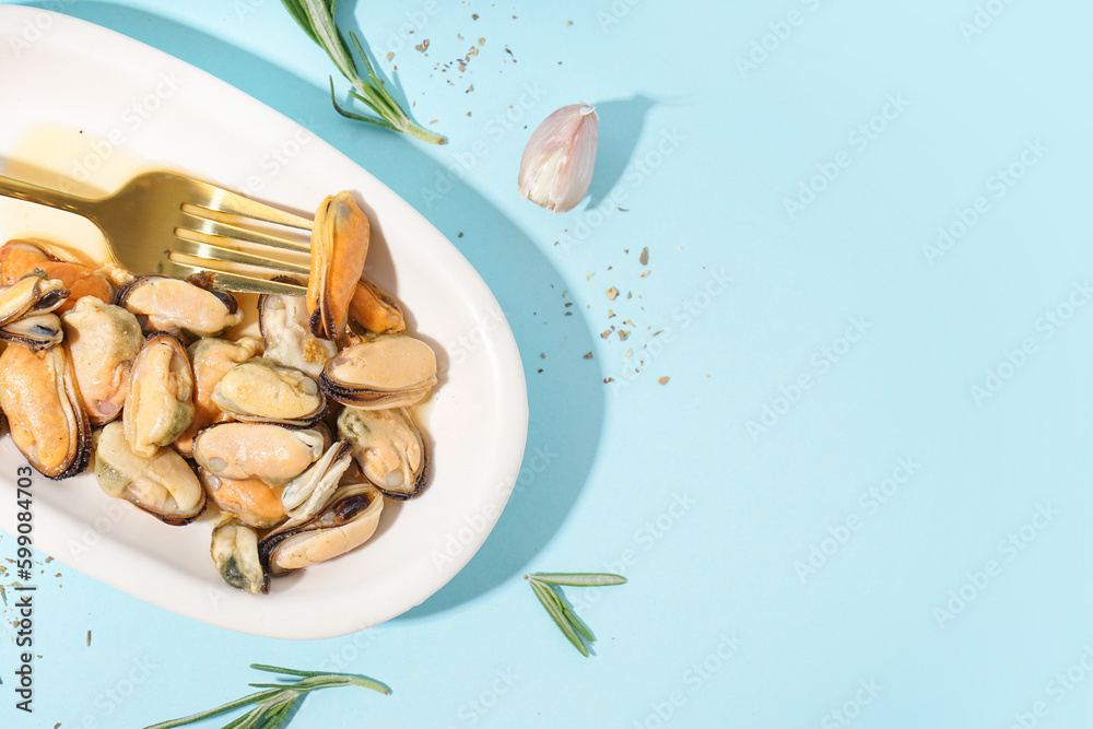 Plate with pickled mussels on blue background