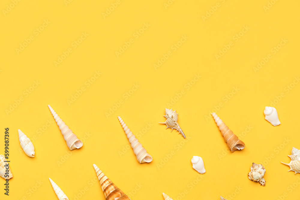 Different sea shells on yellow background