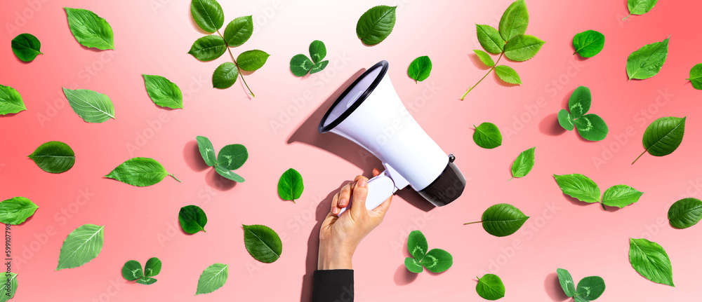 Person holding a megaphone with green leaves