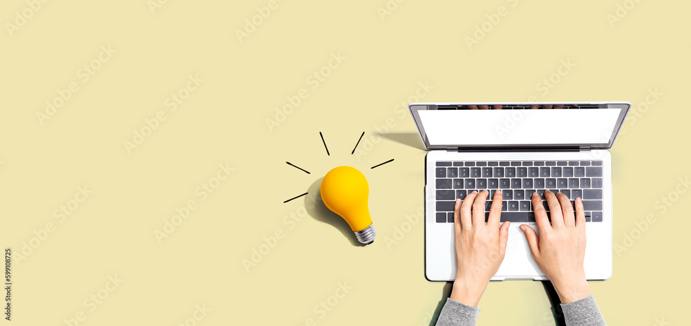 Person using a laptop computer and a light bulb