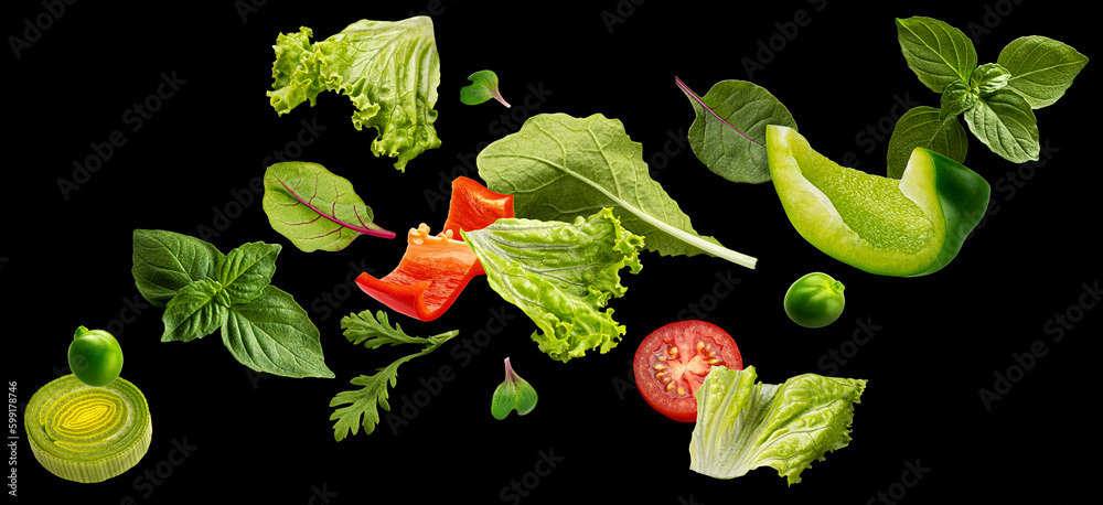 Falling salad leaves isolated on black background