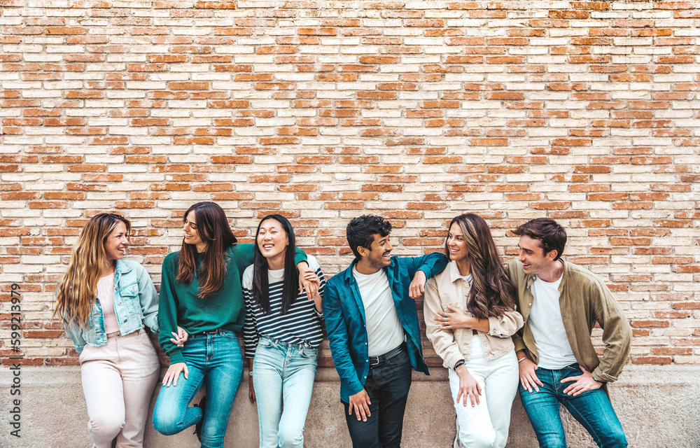 Group of young people having fun outdoors - Happy friends embracing over colorful brick wall - Frien