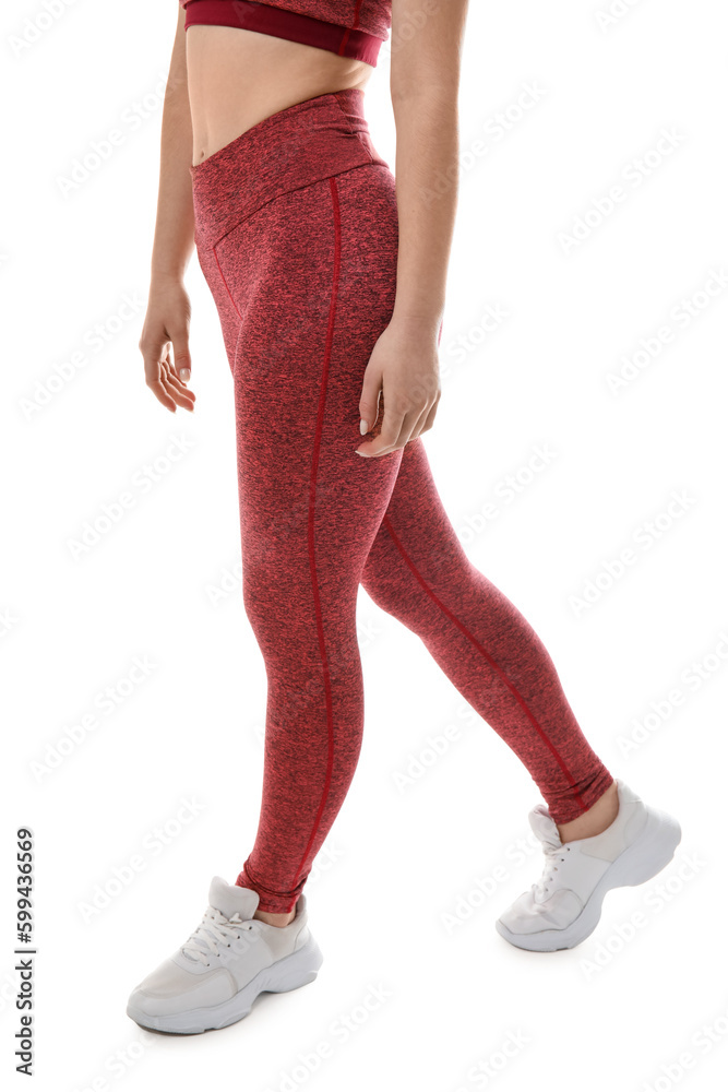 Sporty young woman in leggings on white background