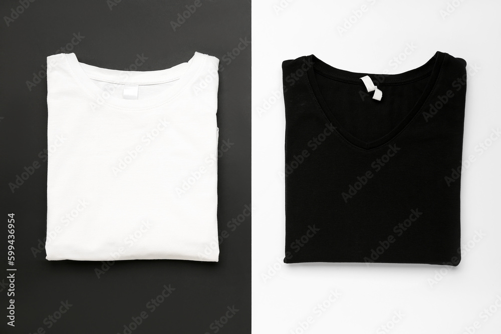 Folded black and white t-shirts on color background