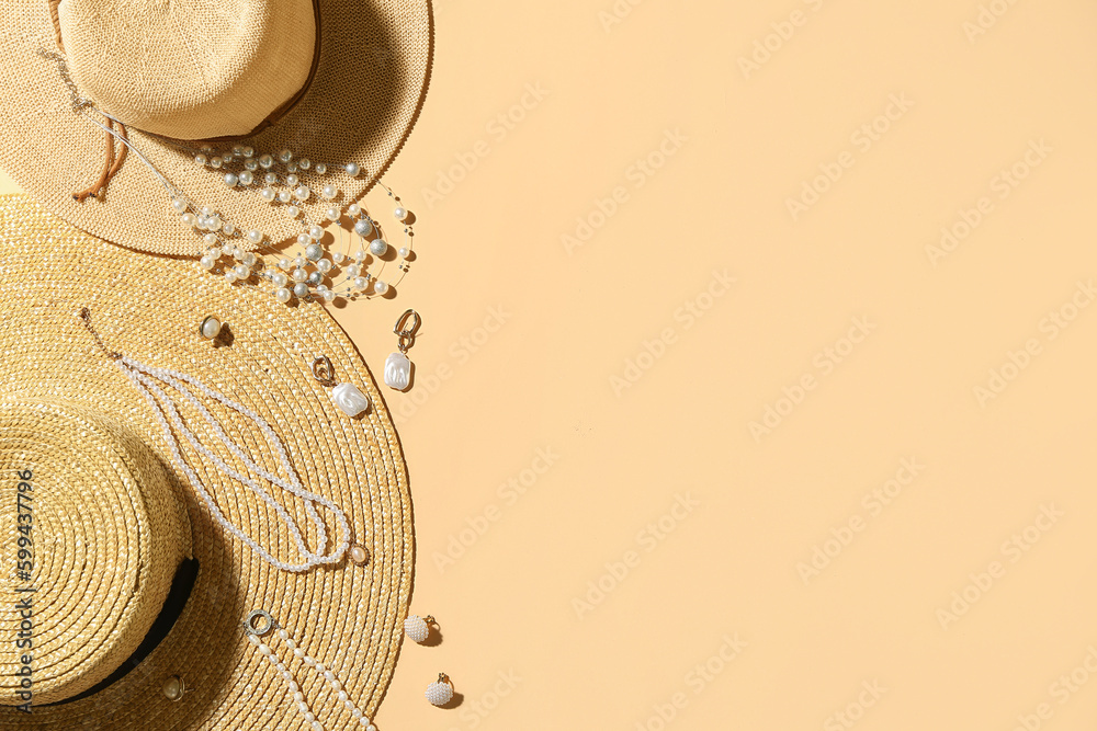 Summer hats with stylish jewelry on beige background