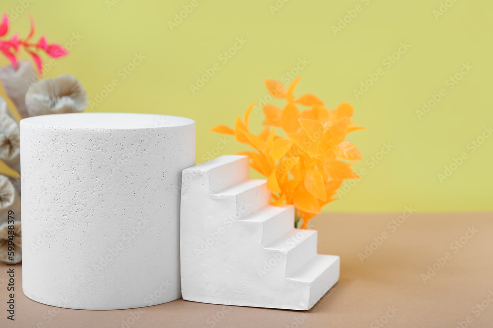 Decorative plaster podiums and seaweed on yellow background