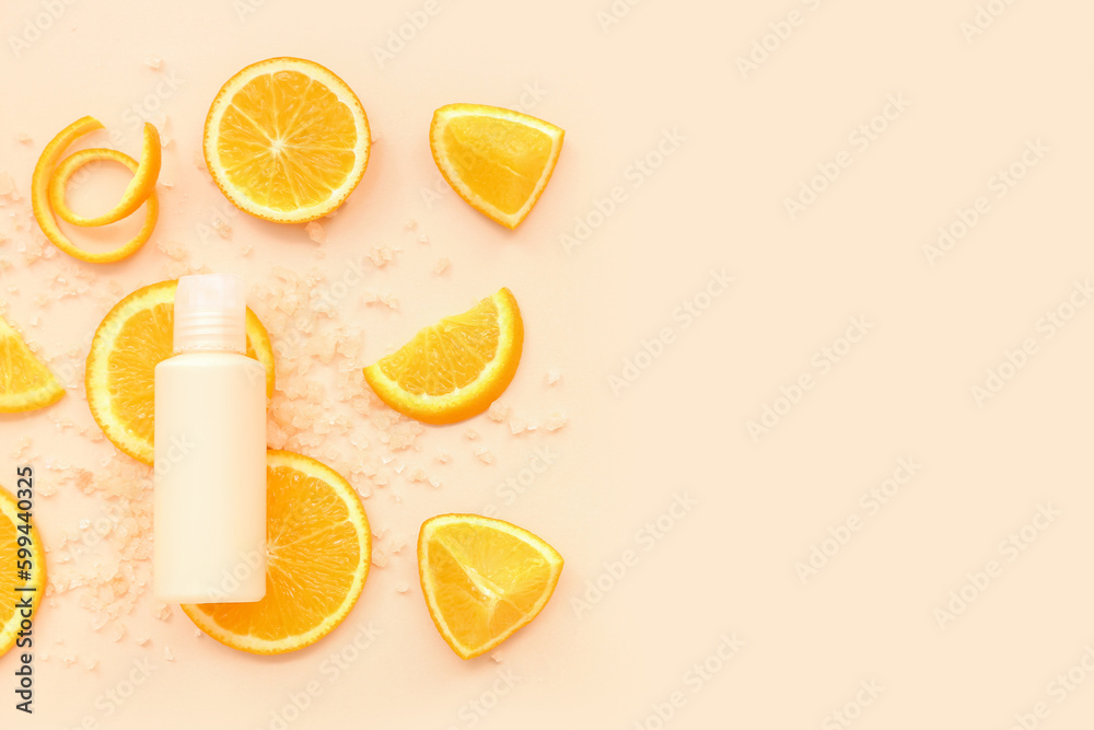 Cosmetic bottle with orange slices and sea salt on beige background